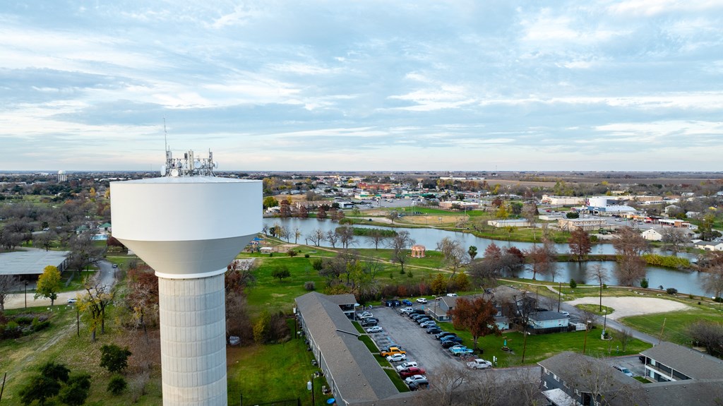 an aerial view of a water tower overlooking a city with a river at Mihir Taylor, Taylor, 76574