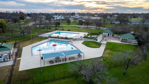 Outdoor swimming pools with splash pad and lounge area at Mihir Taylor Apartments, Taylor, 76574