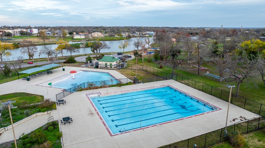 a swimming pool in a park with a city in the background at Mihir Taylor, Texas 76574