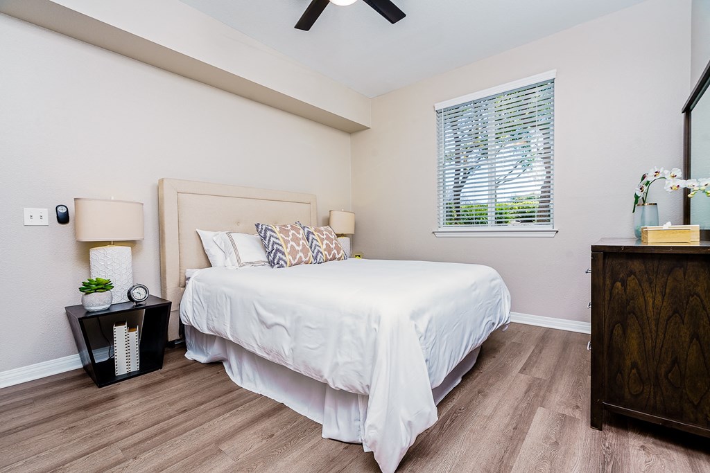 Apartments In Chino Hills. CA - Missions At Chino Hills - Bedroom With Bed, Dresser With Mirror, Ceiling Fan, Oversized Closet, And Window.