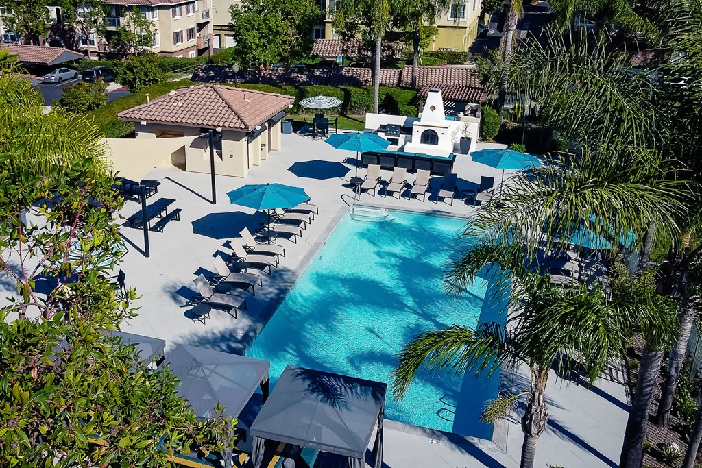 Chino Hills, CA Apartments For Rent - Missions At Chino Hills - Pool With Grill Area, Lounge Chairs, And Umbrellas.