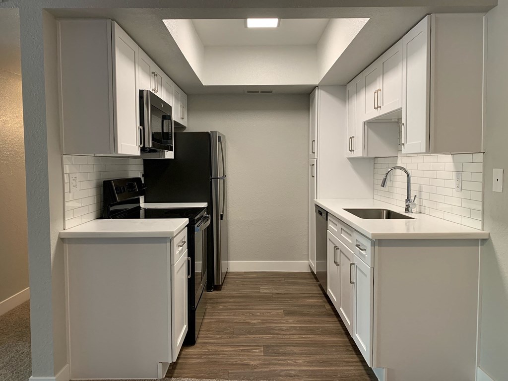 an empty kitchen with white cabinets and a black refrigerator at Monaco at McCormick Ranch, Scottsdale, AZ 85258