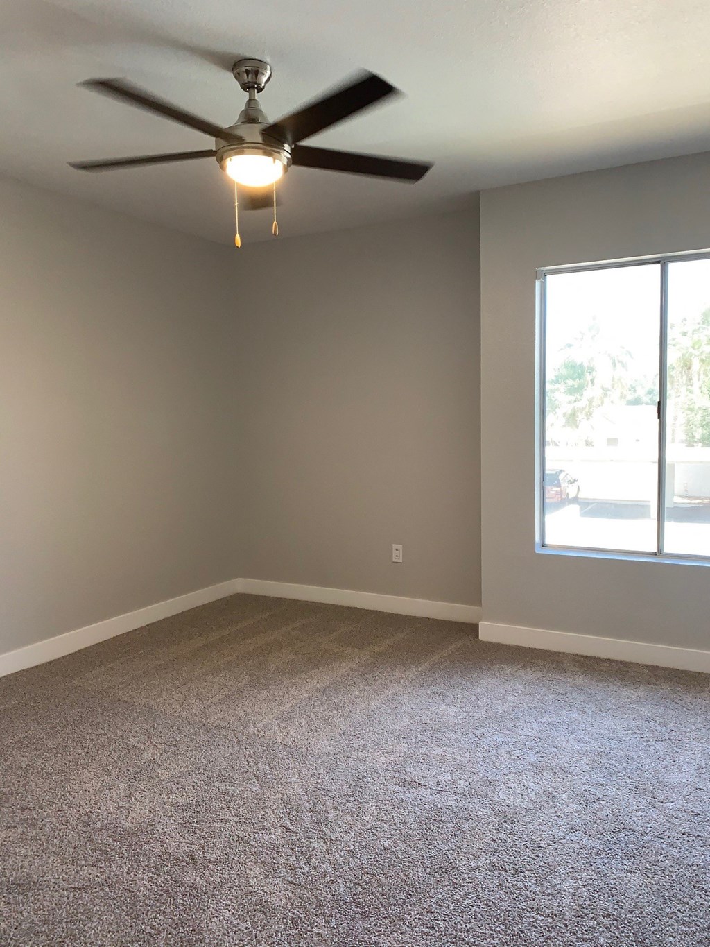 an empty room with a ceiling fan and a window at Monaco at McCormick Ranch, Scottsdale