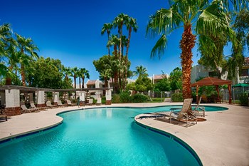 Apartments for Rent McCormick Ranch AZ - Monaco at McCormick Ranch - Resort-Style Pool Area with Palm Trees, Lounge Chairs, and a Cabana - Photo Gallery 2