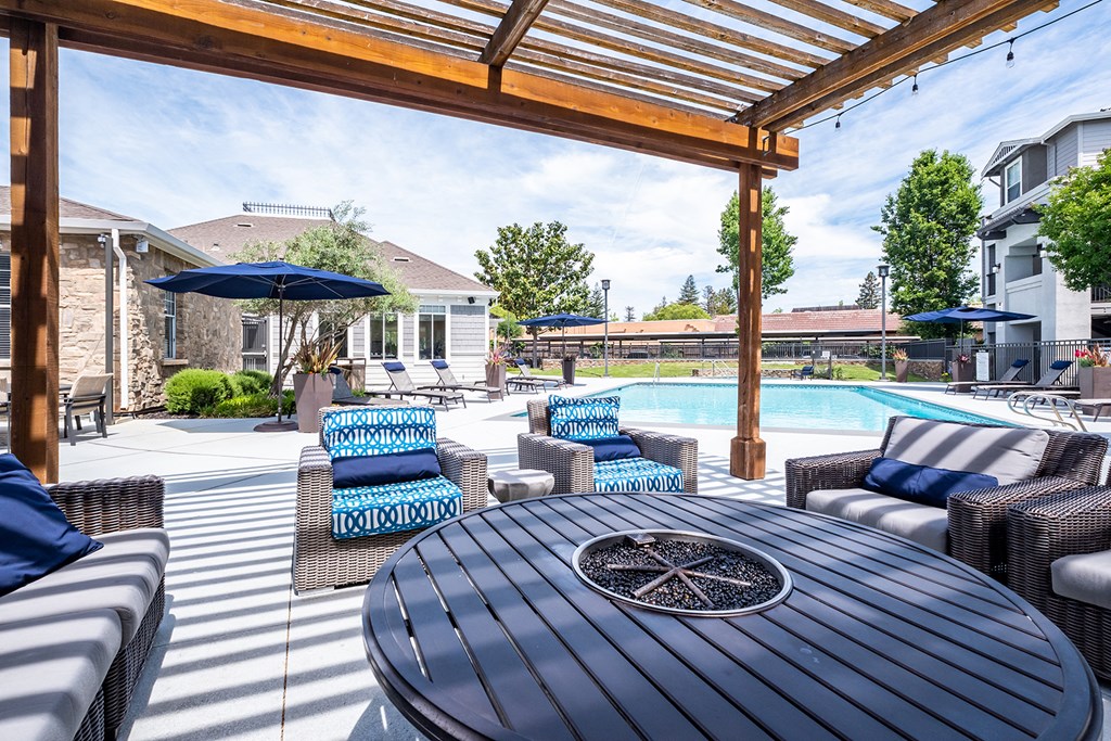 Outdoor seating with fire pit table in pool area