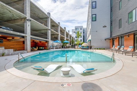 A round glass pool with four chairs around it.