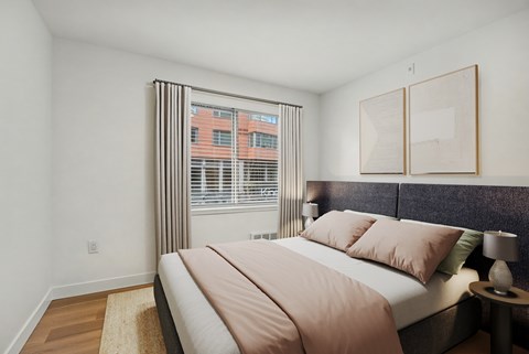 Bedroom with upholstered headboard and window blinds at Noda Apartments, Washington
