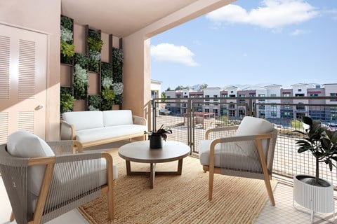 A living room with a couch, chair, and table with a view of a cityscape.