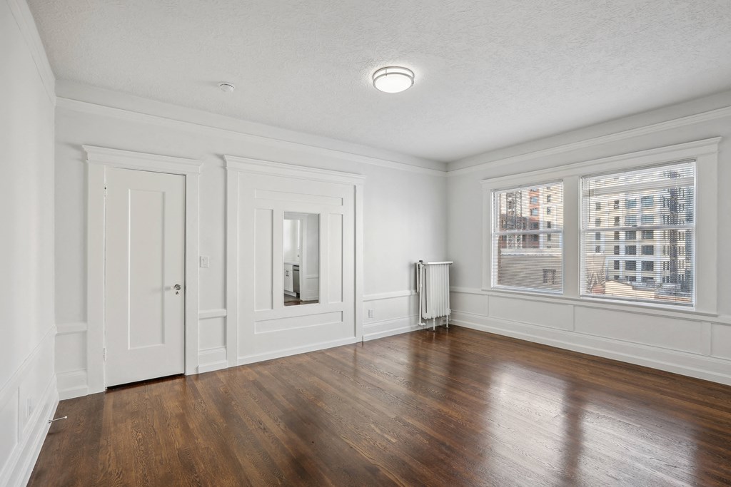 a living room with hardwood floors and white walls