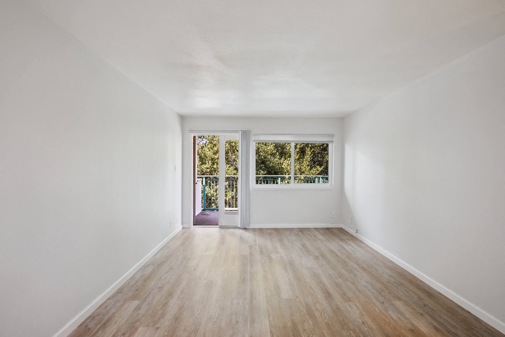 a bedroom with hardwood floors and white walls