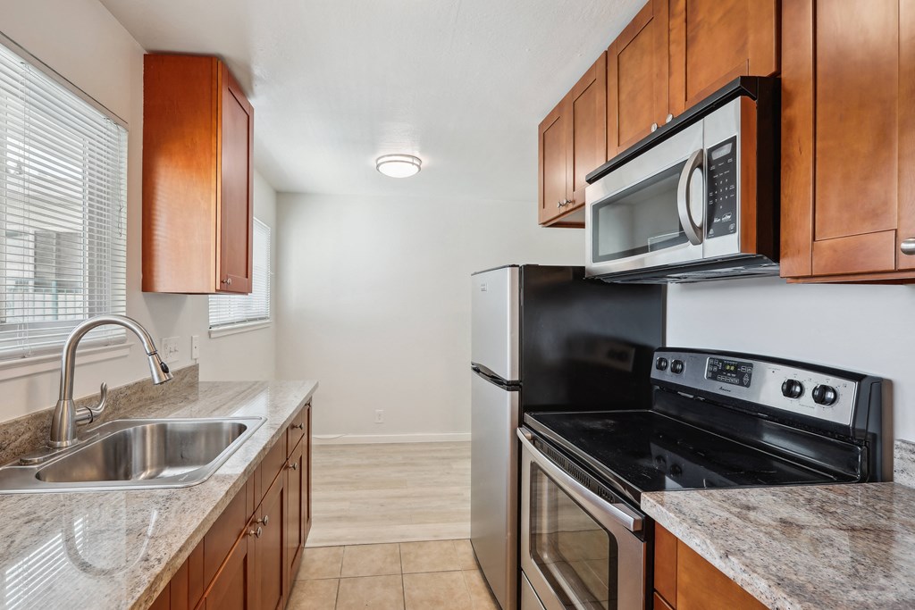 a kitchen with wood cabinets and stainless steel appliances
