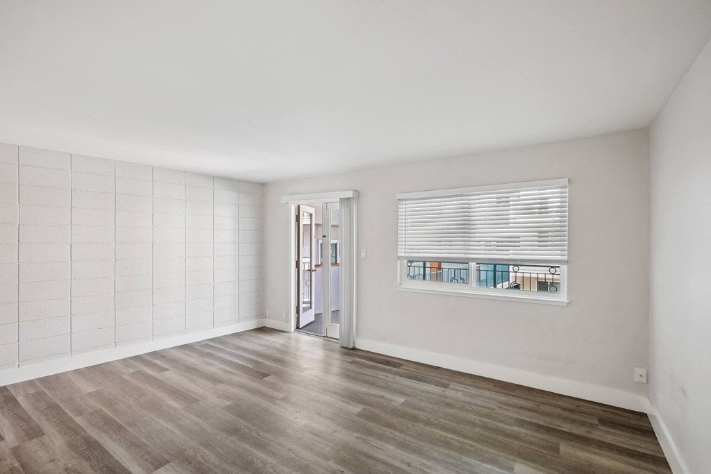 a bedroom with hardwood floors and white walls