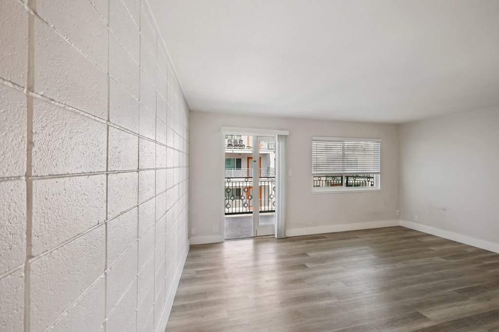 a bedroom with hardwood flooring and white walls