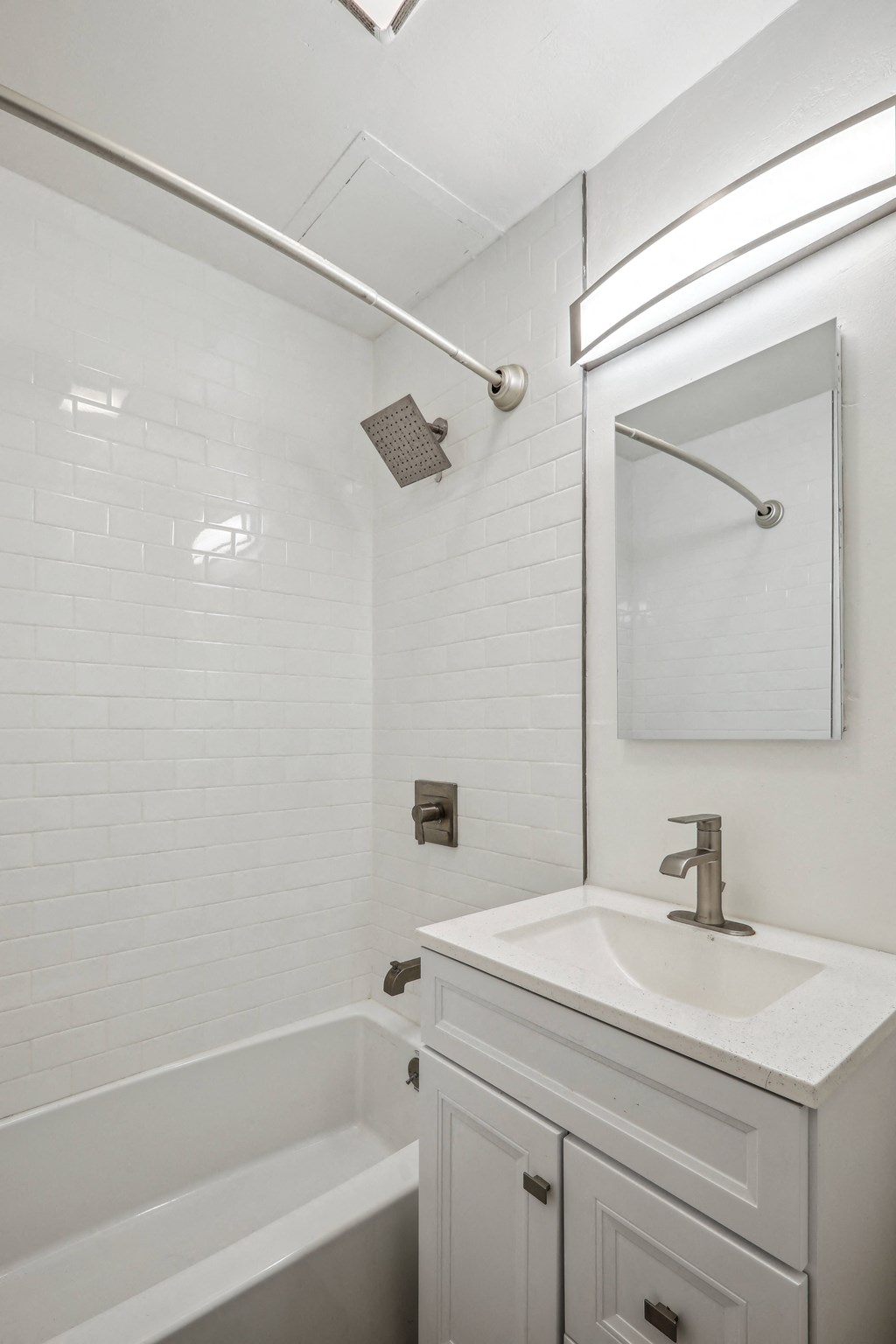 a bathroom with white walls and a white sink and tub