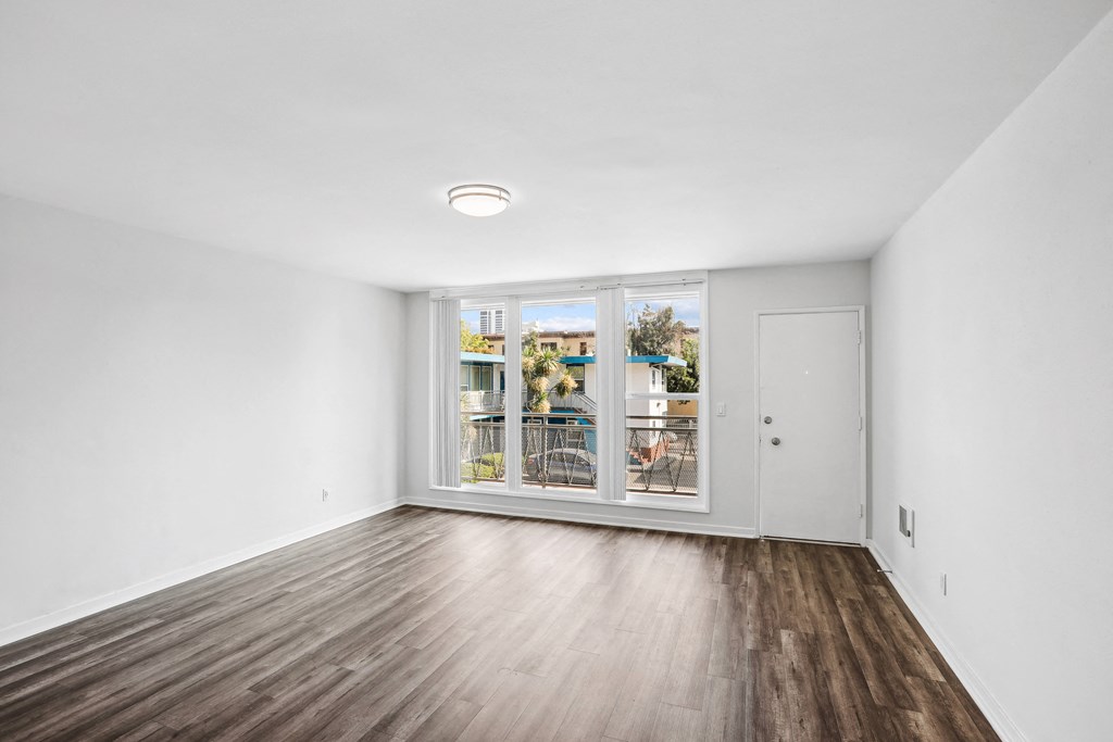 a bedroom with hardwood floors and white walls