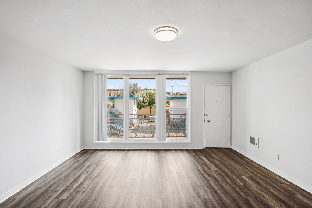 a bedroom with hardwood floors and white walls