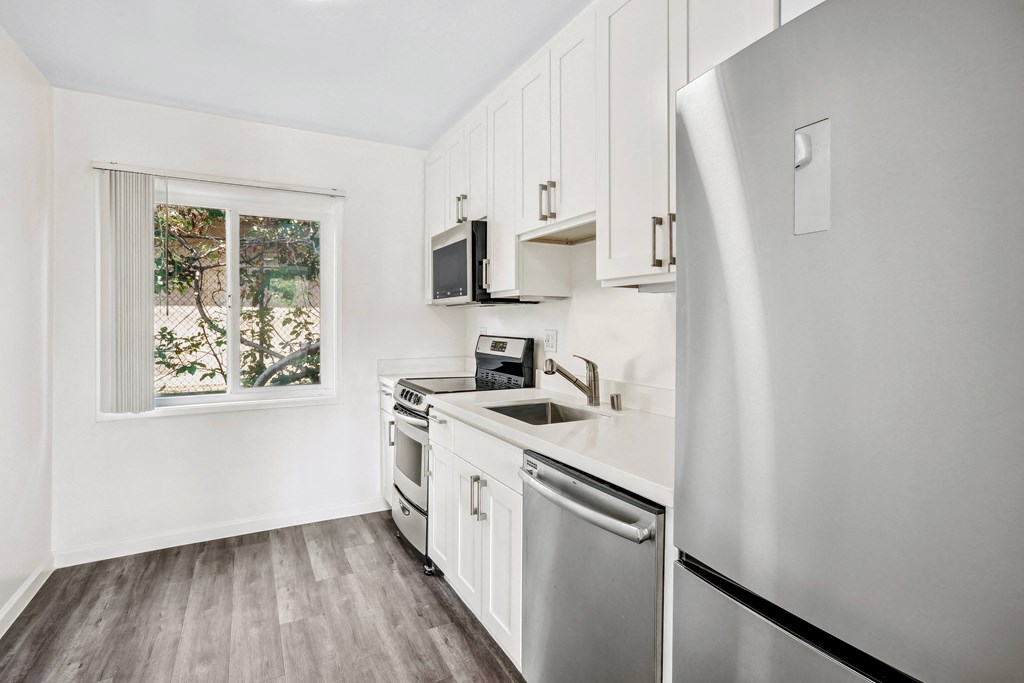 a kitchen with white cabinets and stainless steel appliances