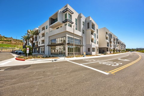 A modern apartment building with a parking lot in front.