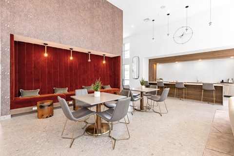 A dining area with a table surrounded by chairs.