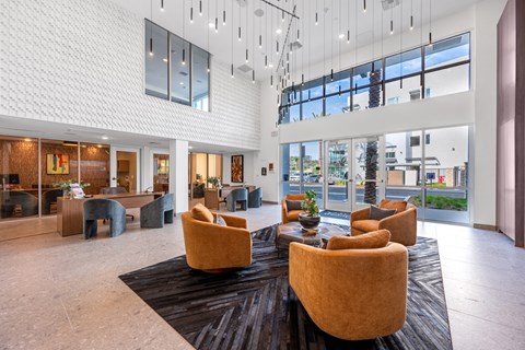 A spacious lobby with a white patterned wall and a large window.