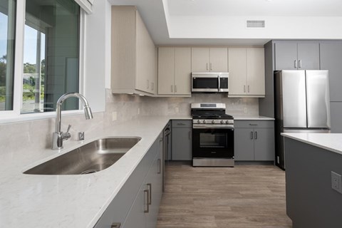 A modern kitchen with a stainless steel refrigerator and a stove top oven.