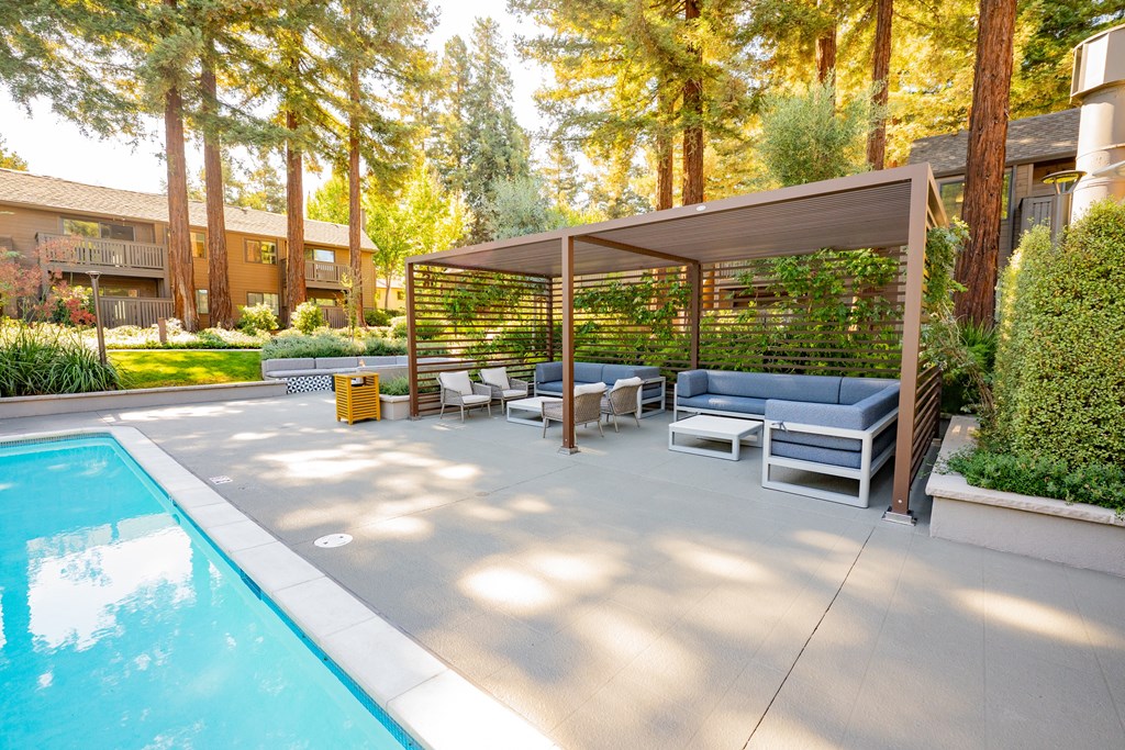 A pool with a sun lounger and a table.