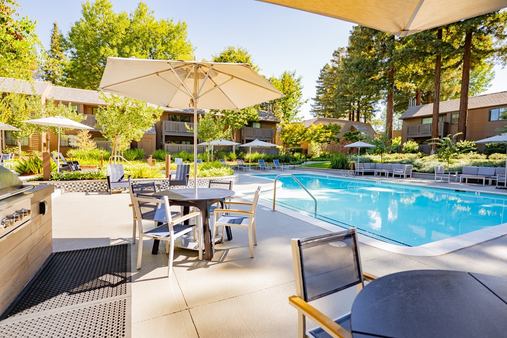 A poolside area with a table and chairs.