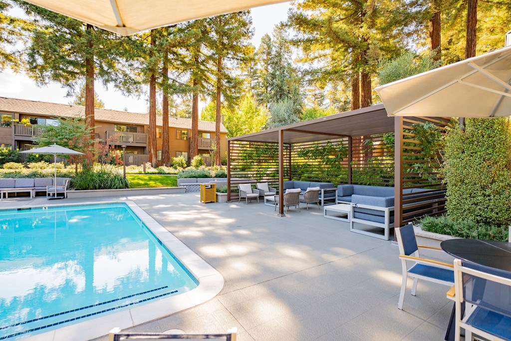 A pool area with a table and chairs.