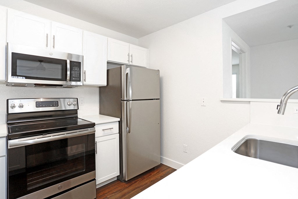 a kitchen with white cabinets and stainless steel appliances
