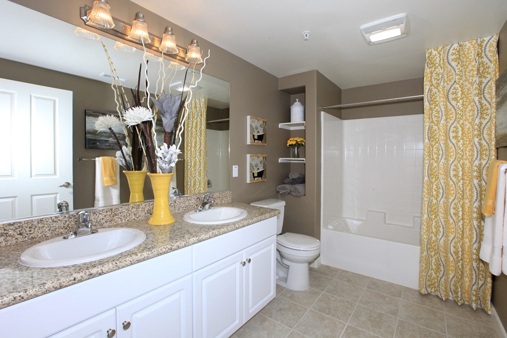 a bathroom with white cabinets and a yellow shower curtain