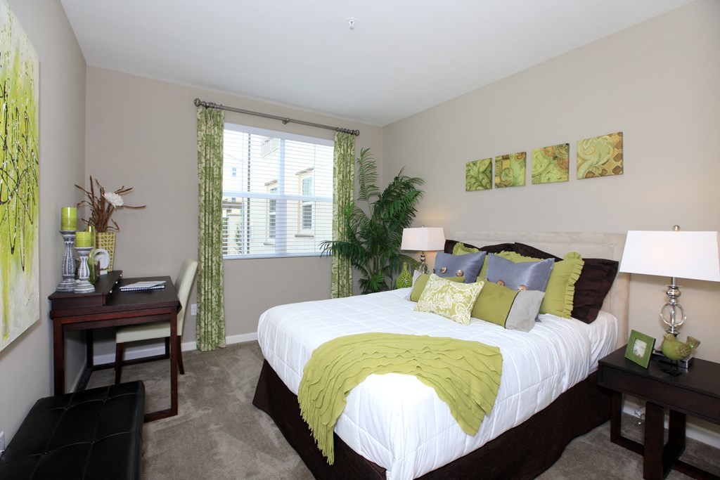 a bedroom with a large bed and a desk and a window