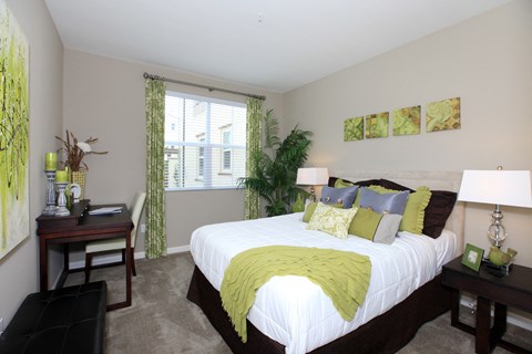 a bedroom with a large bed and a desk and a window