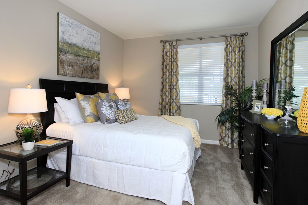 a bedroom with a bed and a dresser and a window