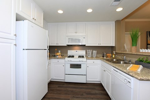 a kitchen with white cabinets and appliances and a counter top