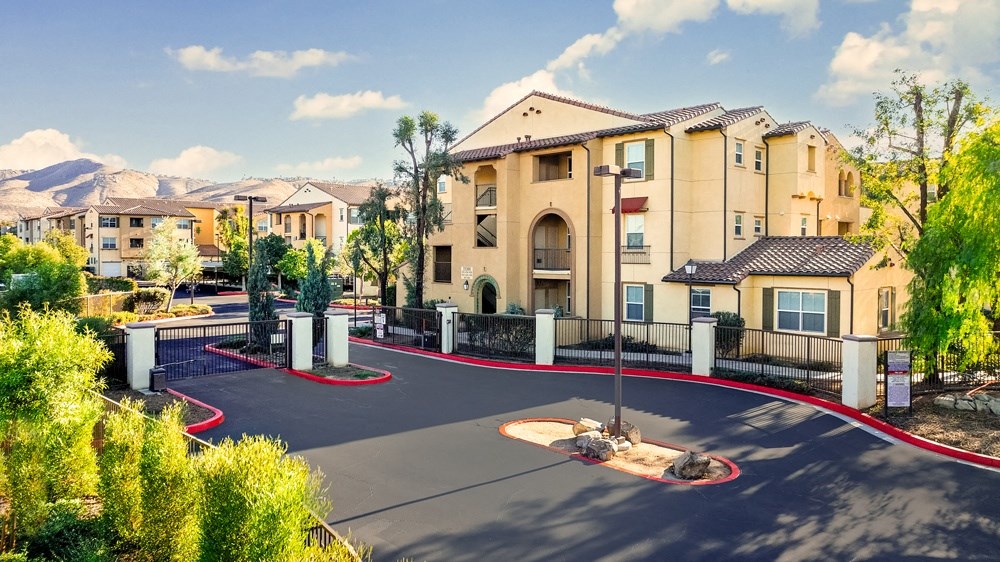 an outdoor basketball court with apartments in the background