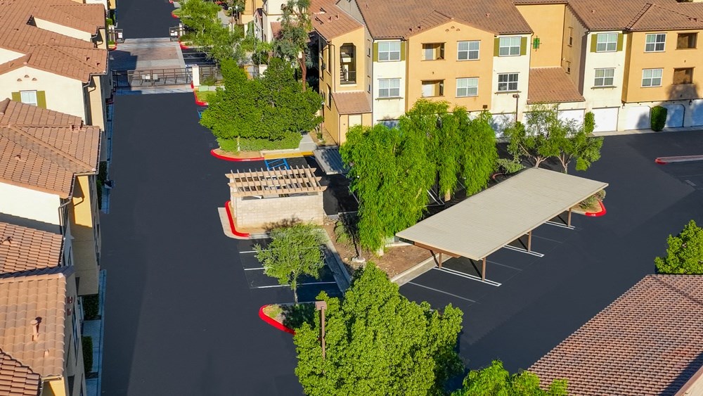 an aerial view of a parking lot with benches and trees