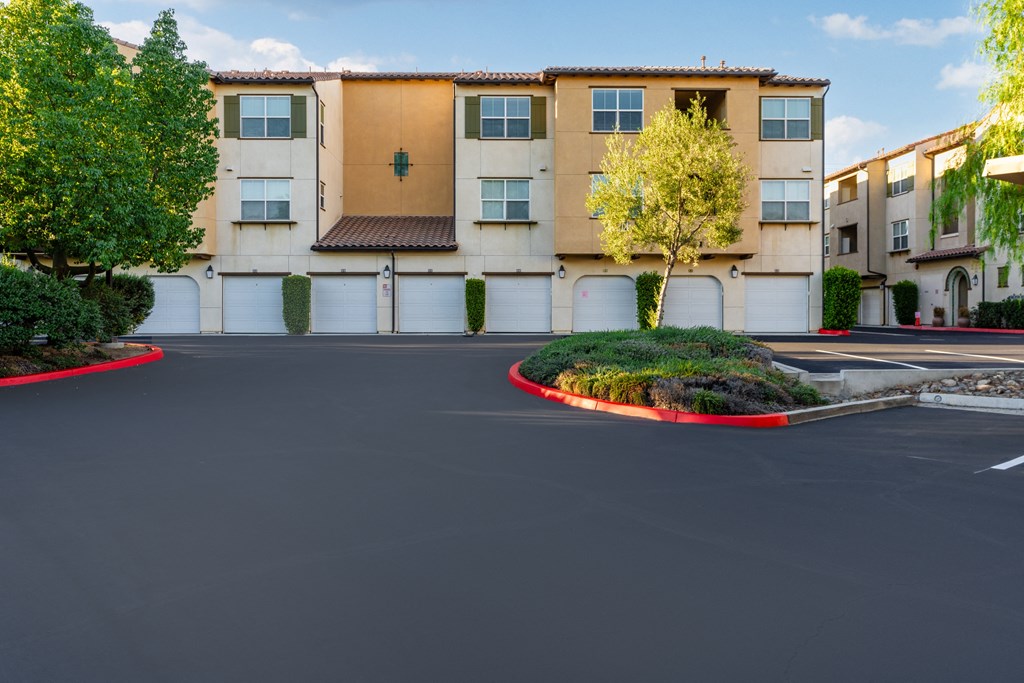 an empty parking lot in front of an apartment building