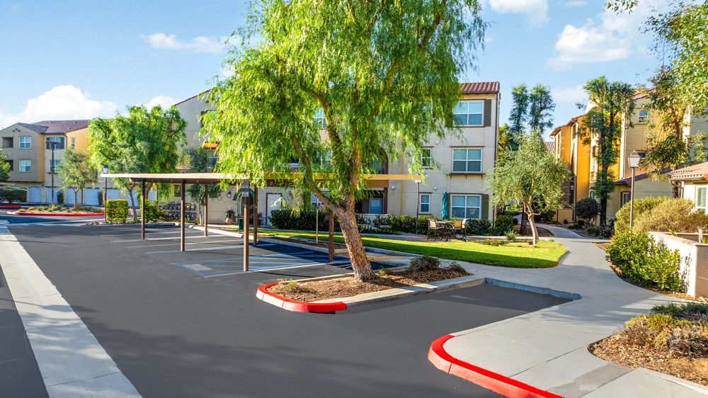 an empty parking lot in front of an apartment building