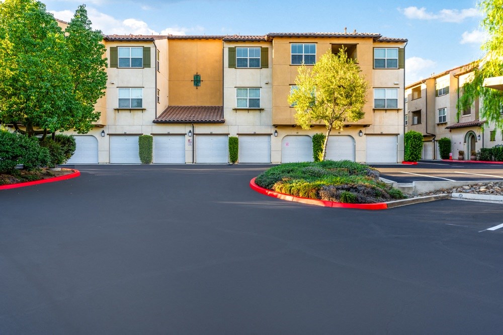 an empty parking lot in front of an apartment building