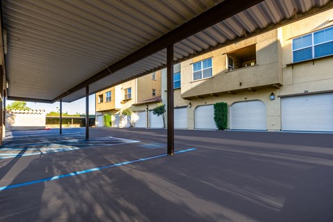 an empty parking lot in front of a building with white garage doors