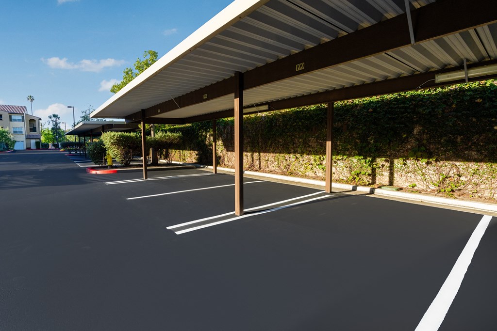 a parking lot with awning and vines on the side of a building