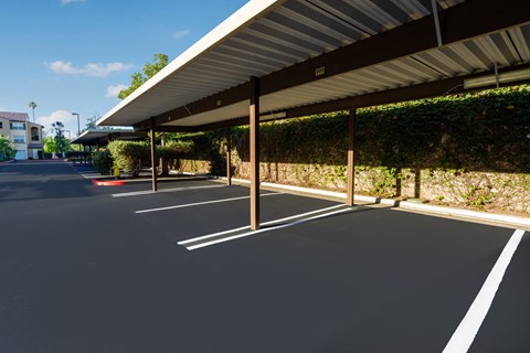 a parking lot with awning and vines on the side of a building