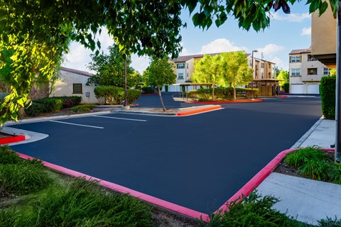 a basketball court in a neighborhood with buildings and trees