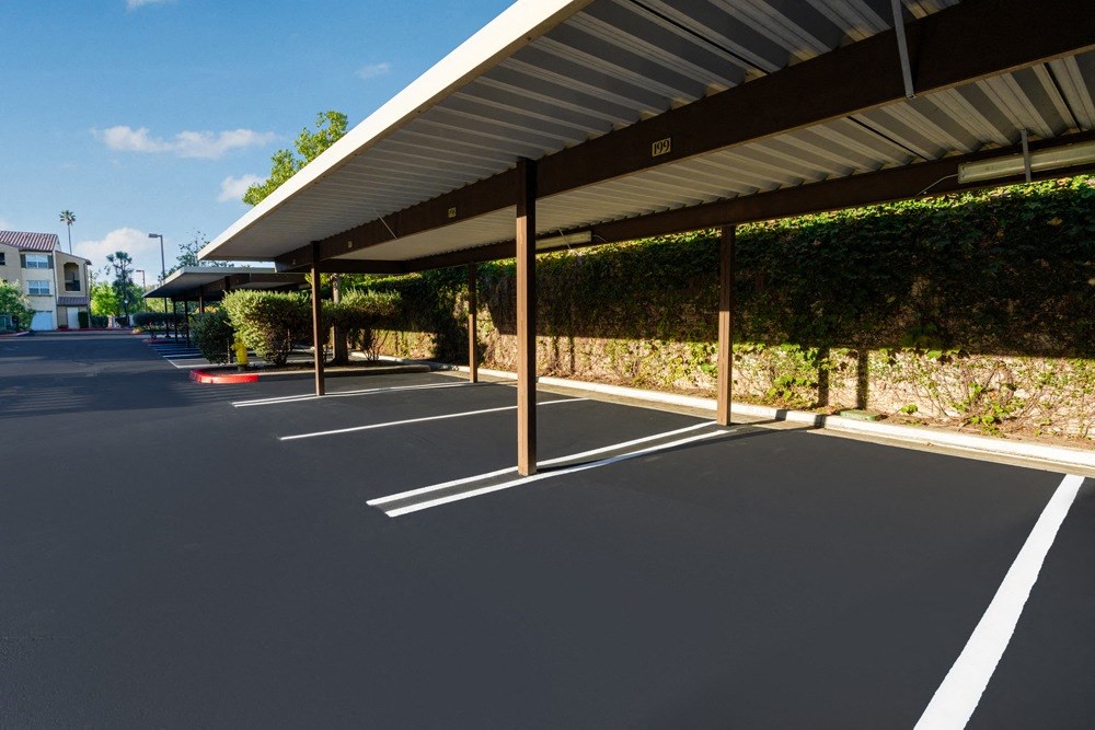 a parking lot with awnings and a building in the background