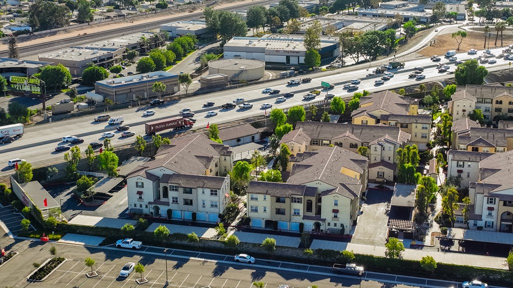 an aerial view of a neighborhood with cars on the street and houses