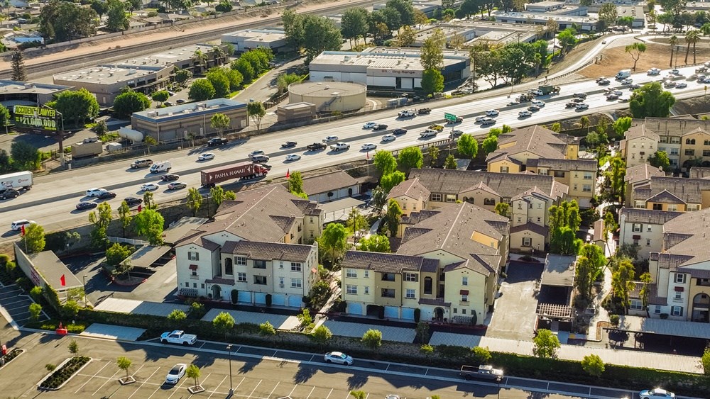 an aerial view of a city with houses and cars on the street