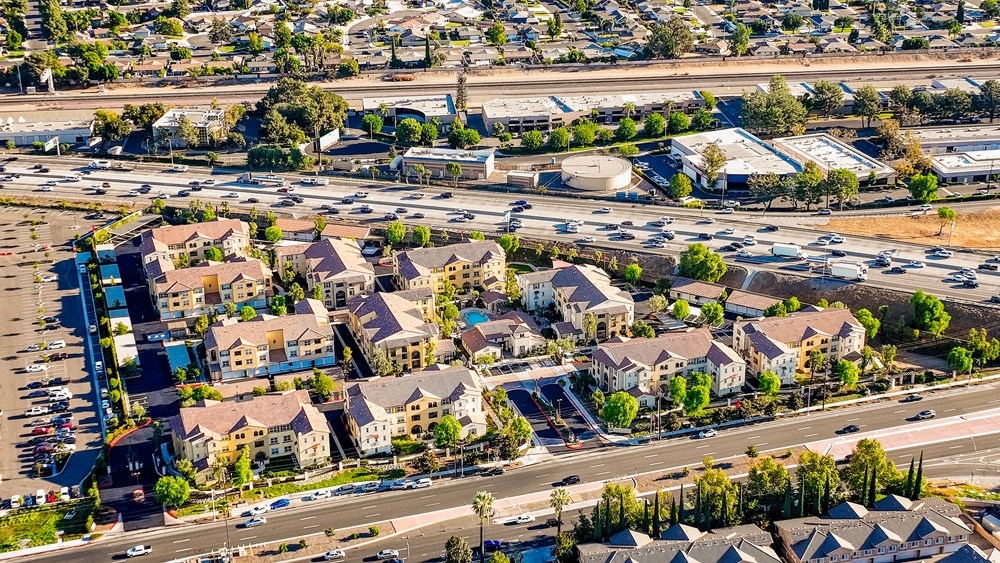 an aerial view of an urban area with cars on a freeway