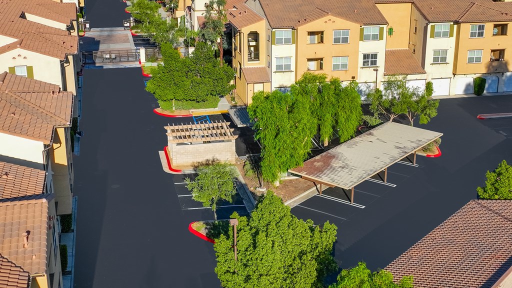 an aerial view of a parking lot with benches and trees