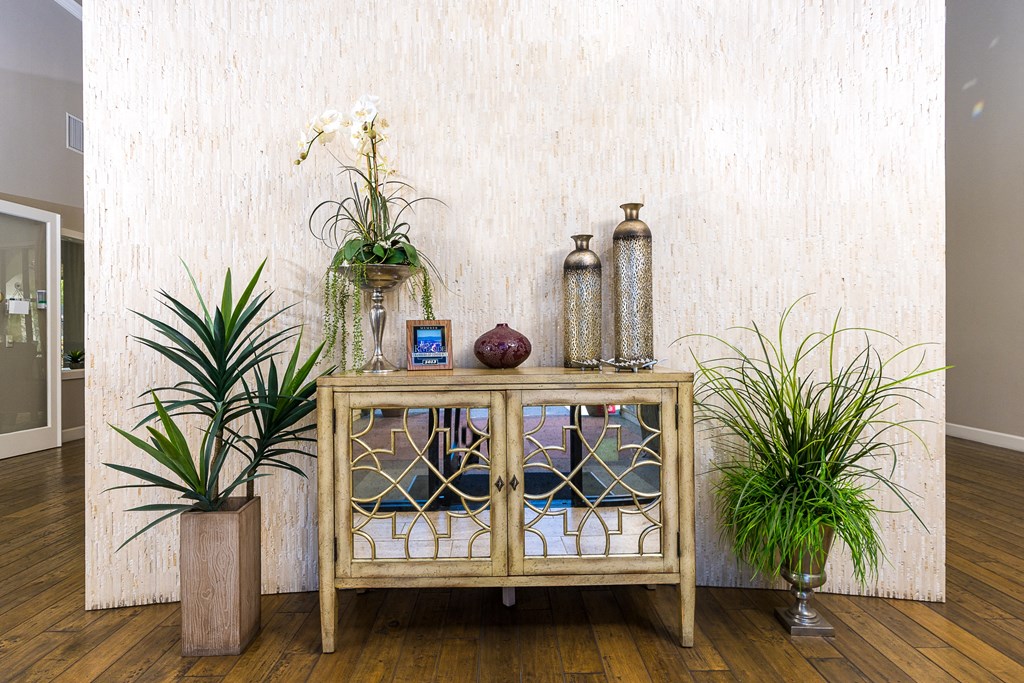 a wooden cabinet with glass doors with plants on top of it