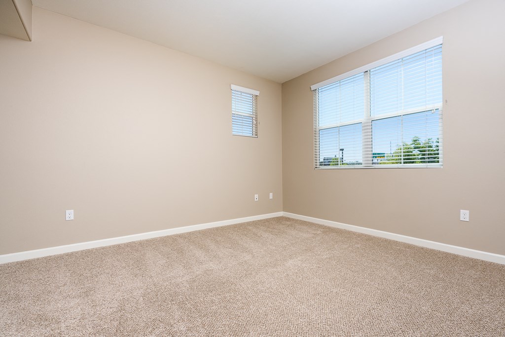 an empty bedroom with a large window